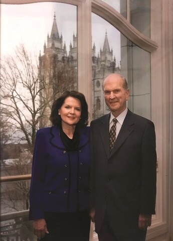 Russell M. Nelson and Wendy Watson Nelson stand in front of a window near the Salt Lake Temple.