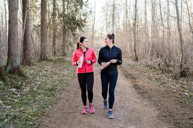 Two friends talking and walking after workout.