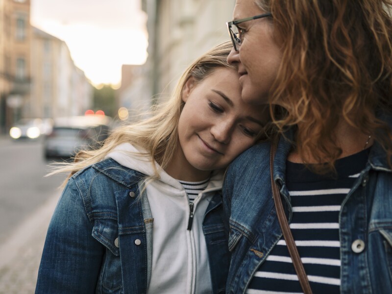 Smiling mother and daughter in city