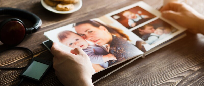 The,Hand,Man,Holding,A,Family,Photo,Album,Against,The