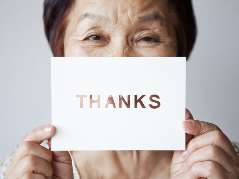 an elderly woman holding a card