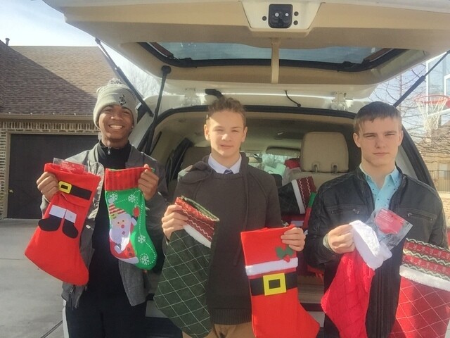 Xavier, Quinn, and Riley delivering gifts to seniors in their community.