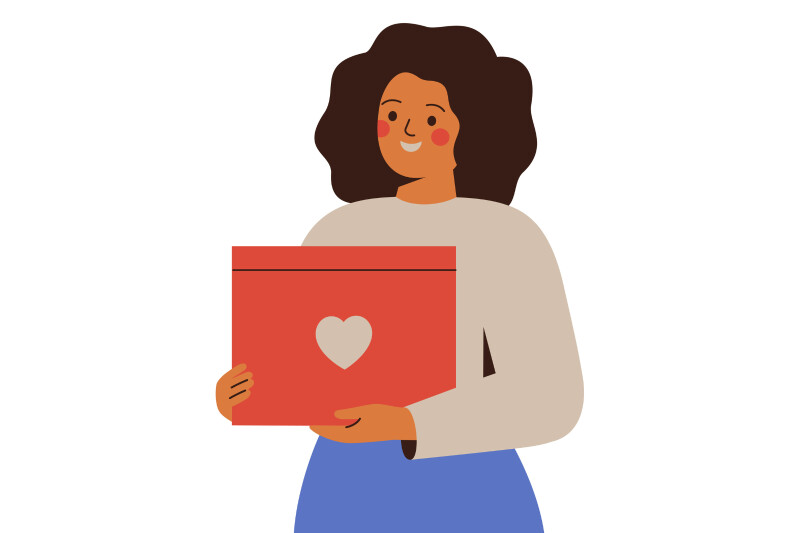 A woman holds a gift box with a heart symbol on the front