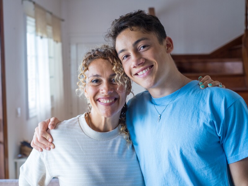 Portrait of grateful teenager man hug smiling middle-aged mother show love and care, thankful happy grown-up son in embrace cheerful mom, enjoy weekend family time at home together, bonding concept
