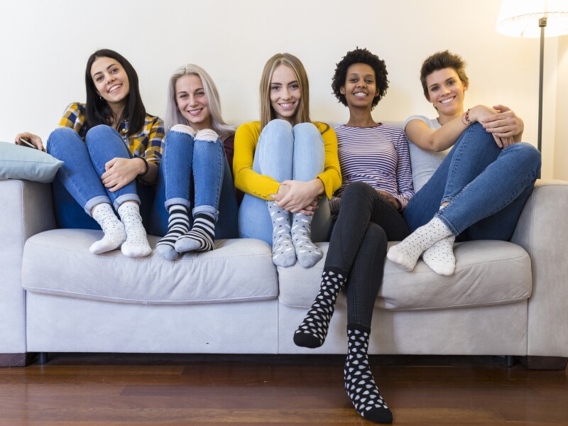 Portrait of group of female friends sitting on sofa in living room