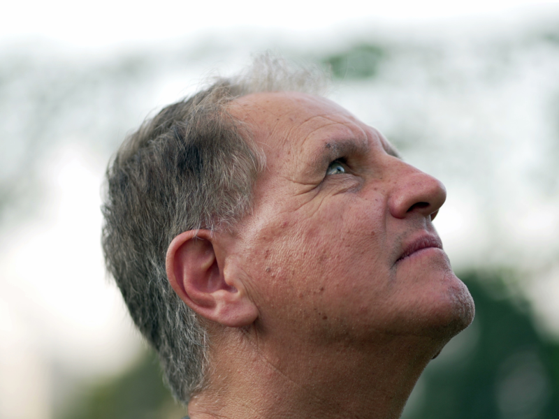 Meditative senior man looking up at sky with serious expression