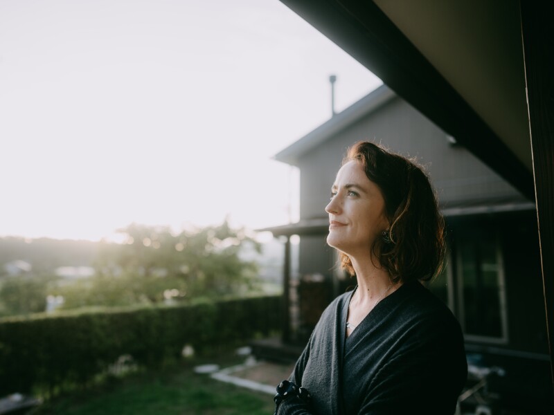 Woman pondering in patio at sunset