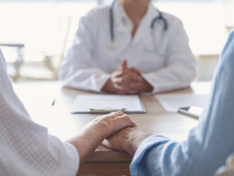 Mature couple holding hands at a doctors office