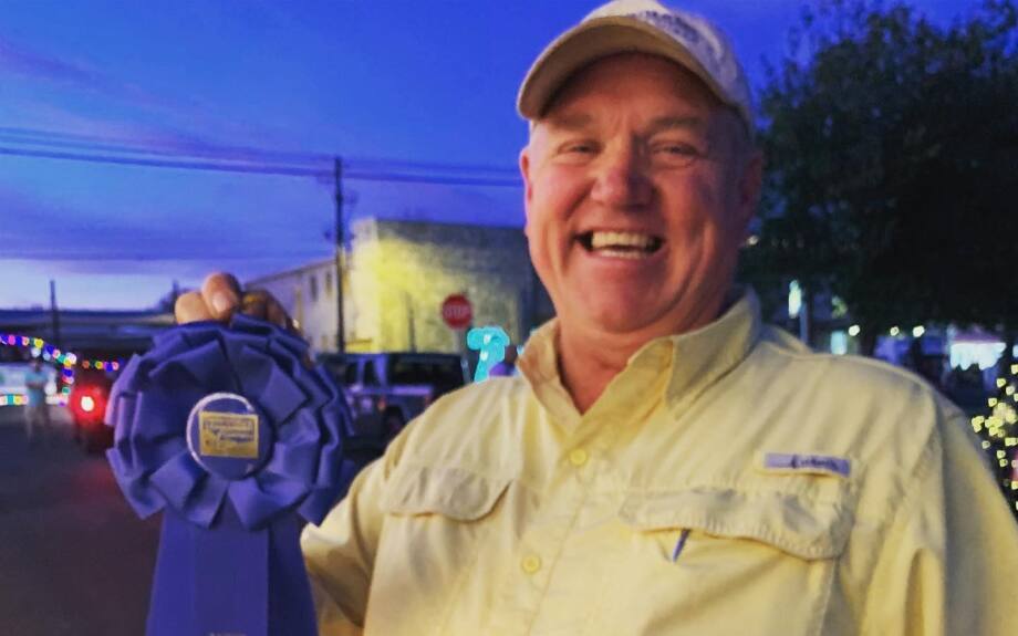 Rick Weirich with a blue ribbon the branch won for their float.
