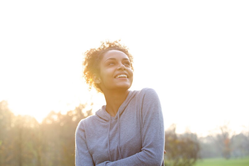 Happy young woman thinking and looking up