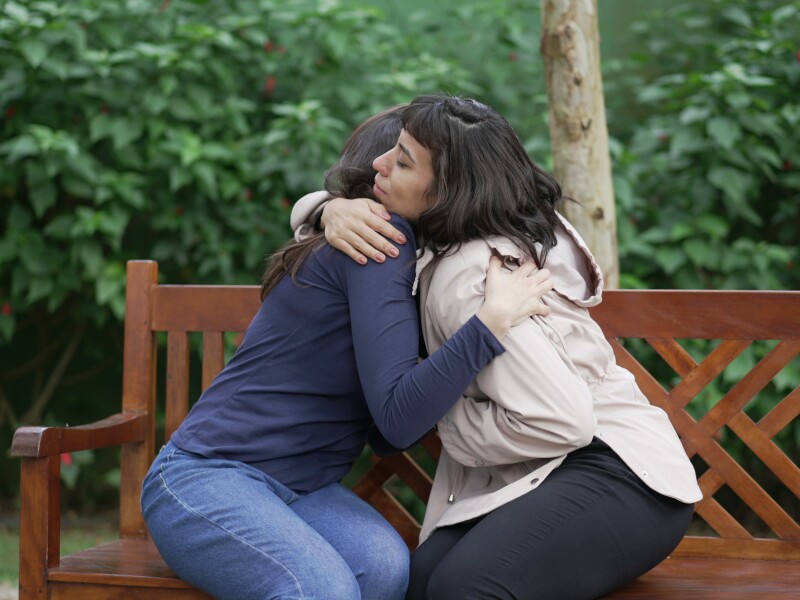 Sympathetic female friend in SUPPORT with suffering woman. Person in sorrow embracing supportive companion