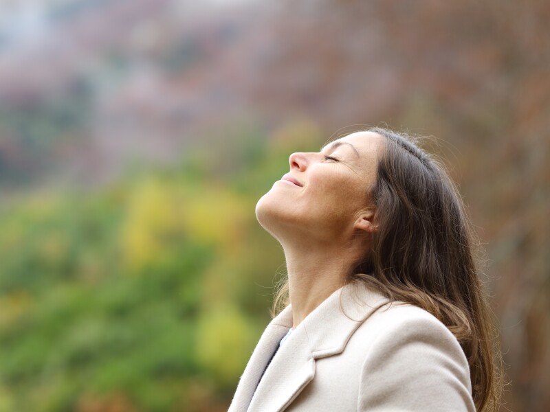 Middle aged woman breathing fresh air in a forest in winter