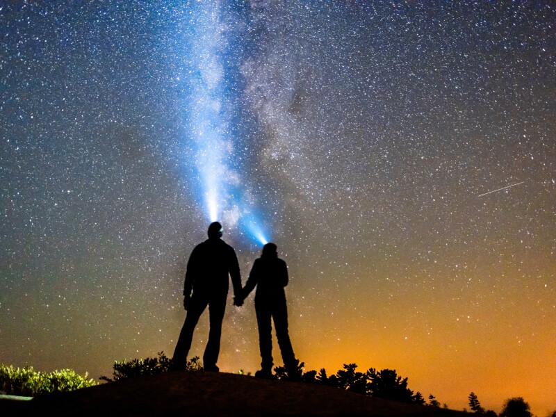 Silhouette of Couple Holding Hands With Milky Way Galaxy Night Stars and Headlamp