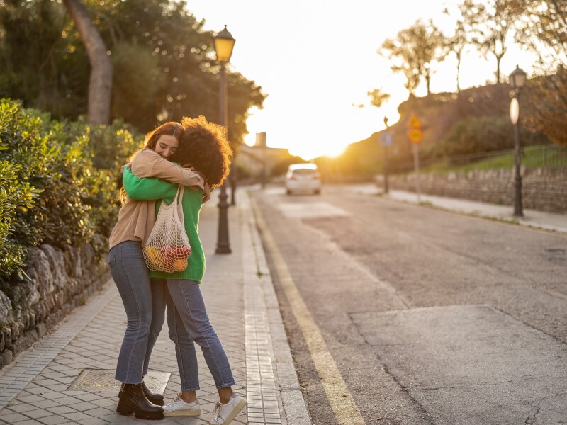 hug of friends shopping on the street