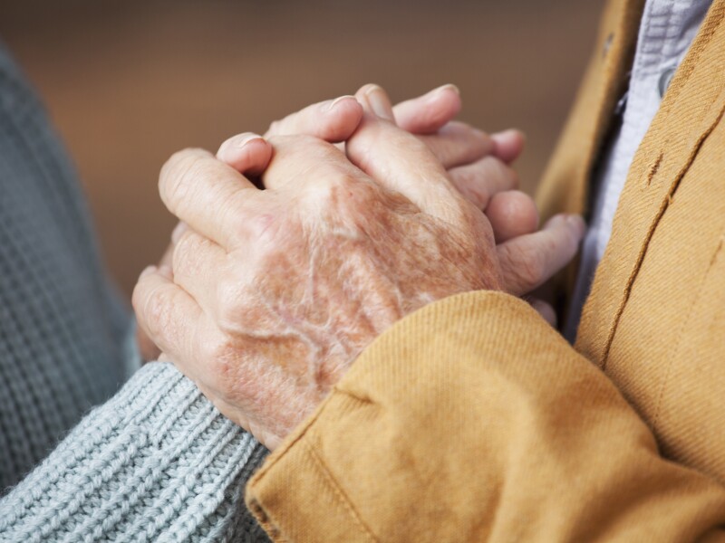 Close up of older couple holding hands