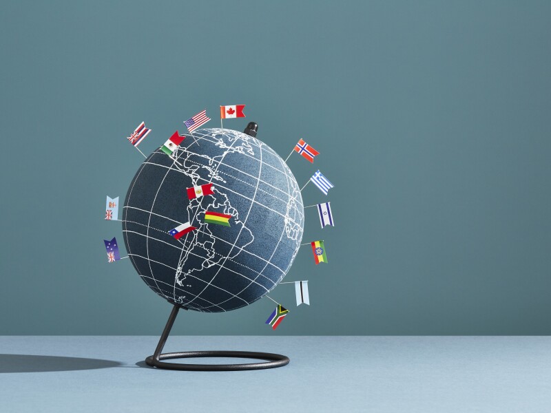 A world globe marked with several national flag pins