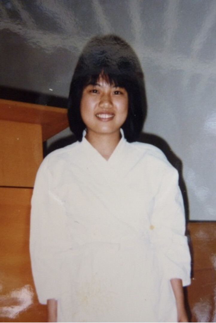 A young woman wearing white smiles.