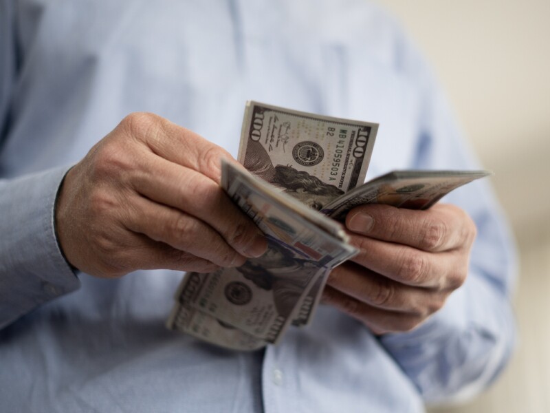 Adult man counting dollars at home