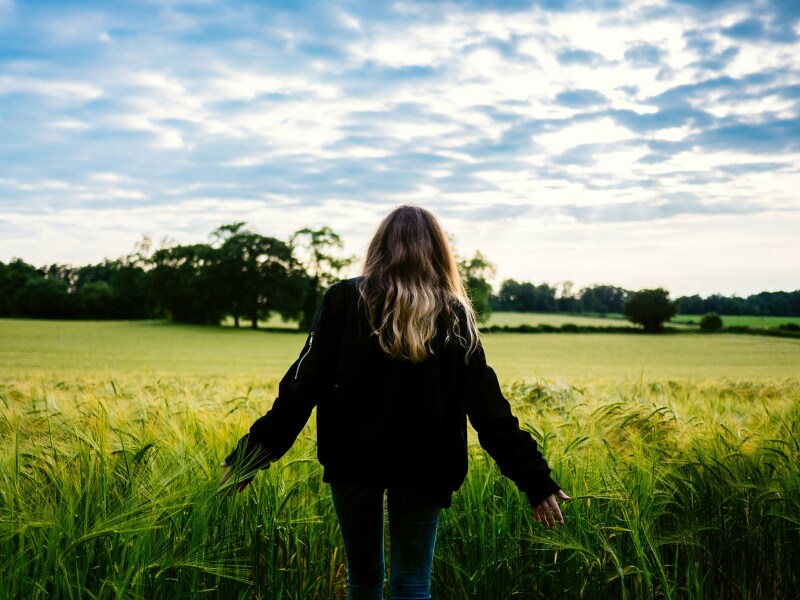young woman walking through field.jpg
